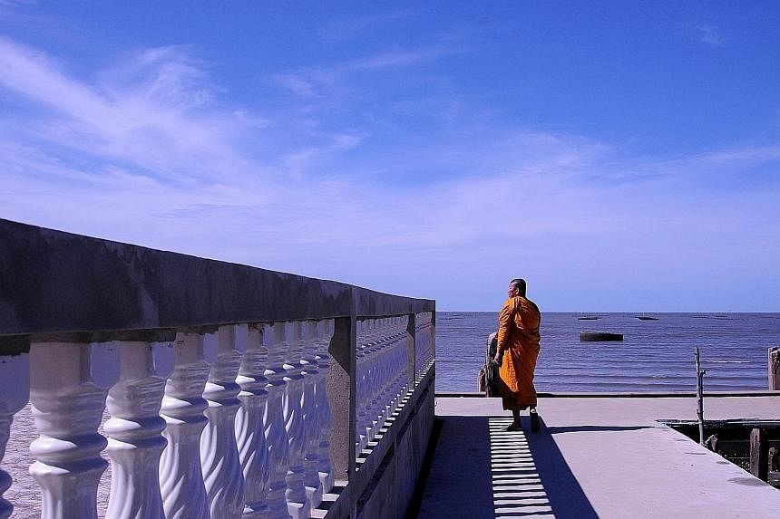 Phra Somnuek Athipanyo, the abbot of Wat Khun Samut, a Buddhist temple on the coast of the Gulf of Thailand some 30km south of Bangkok, patrols the parapet inspecting his temple's defences against the sea.
