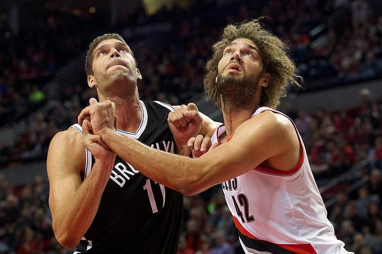 Brooklyn Nets' Brook Lopez (left) with twin Robin, who was with the Portland Trail Blazers last season, is considered the better player.