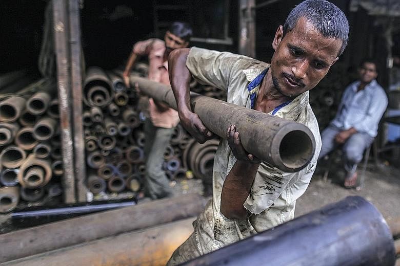 Workers handling an iron pipe at the wholesale steel and iron market in Mumbai, India, late last week. Indian steel imports in the first two months of the fiscal year, starting April 1, jumped 55 per cent to 1.67 million tonnes, according to data fro