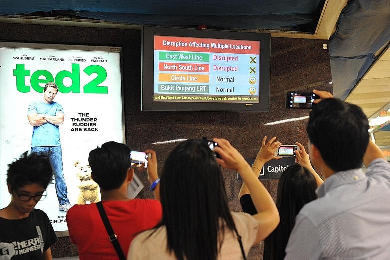 Commuters outside Bishan MRT station (far left) waiting for buses after train services were disrupted last night. Over at City Hall MRT station, commuters snapped photos of a signboard displaying information on the disruption of services on the East-