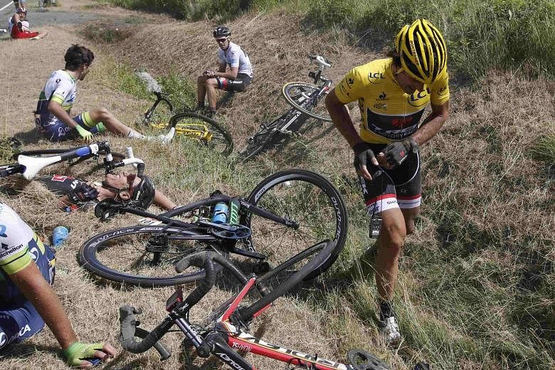 Race leader and yellow jersey holder, Trek Factory rider Fabian Cancellara of Switzerland (left), walking away from the carnage following a pile-up involving more than 20 riders. He pulled out of the race later because he broke two vertebrae in his l