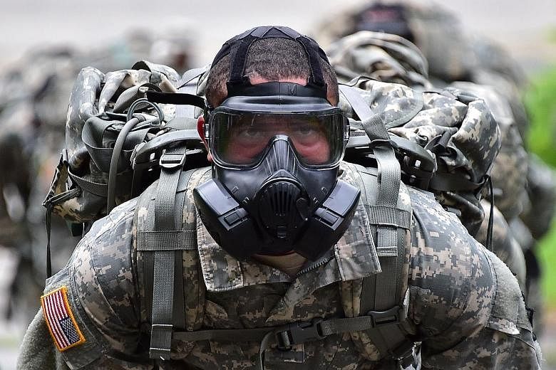 A US soldier during a competition to test individual skills at a US army base in South Korea yesterday. The troop reductions come as President Barack Obama announced that the US-led coalition fighting ISIS will step up its campaign in Syria, while ca