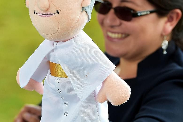 A woman holding a puppet depicting Pope Francis, outside the Pontifical Catholic University of Ecuador, before the arrival of the pontiff for a meeting with students and educators in Quito on Tuesday.