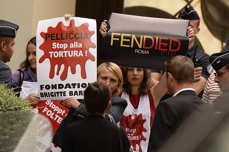 Animal rights activists holding posters reading "Fur: Stop torture" at the protest against Fendi in Paris.