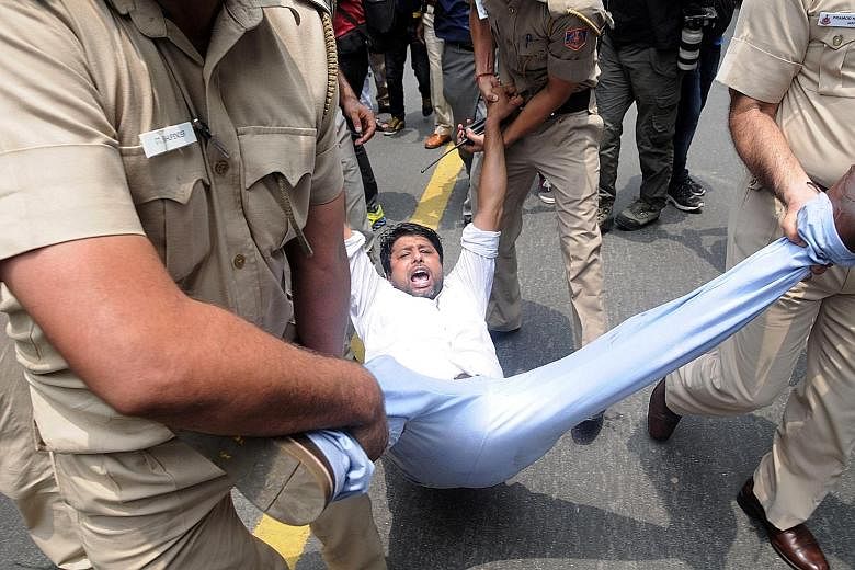 Police detaining a Youth Congress activist protesting near a Bharatiya Janata Party office in Madhya Pradesh on Wednesday against the government recruitment and admission scam.
