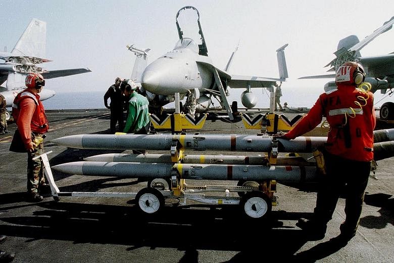Crewmen handling SeaSparrow rockets on board a US aircraft carrier. The 12-country Nato consortium oversees development and shares the costs of the SeaSparrow missile, an advanced ship-borne weapon that is designed to destroy anti-ship sea-skimming m