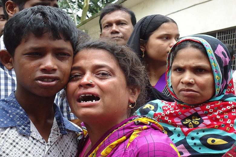 Relatives of victims of the stampede in Bangladesh's northern city of Mymensingh grieving over the loss of their loved ones yesterday. There were two children among the dead. Most of the others were poor and emaciated women.