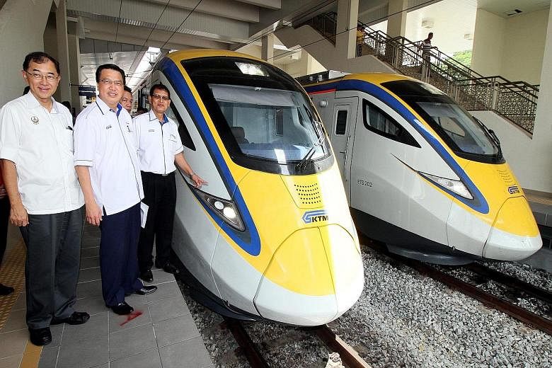 (From left) Perak state executive council member Mah Hang Soon and Malaysian Transport Minister Liow Tiong Lai join KTM president Sarbini Tijan as he checks out the new electric trains.