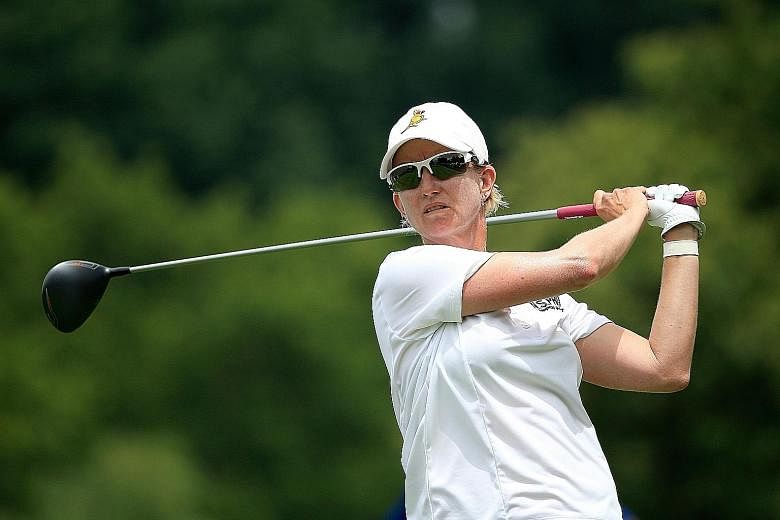 Seven-time Major champion Karrie Webb of Australia teeing off on the 18th hole in the first round of the US Women's Open, which she has won twice before. While she is joint leader, holder Michelle Wie is already six shots back, although she remains u