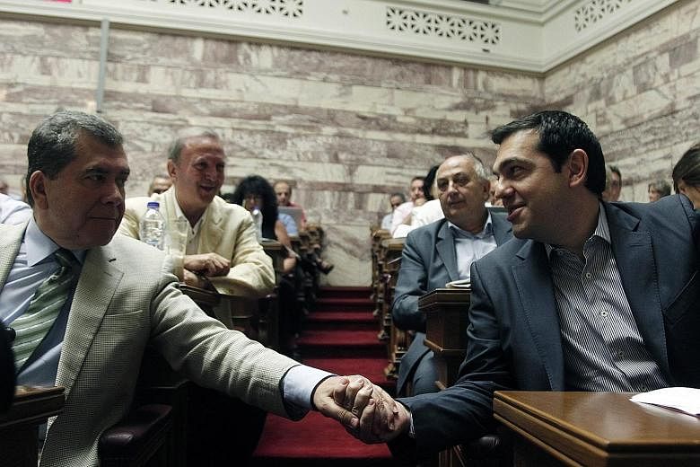 Greek Prime Minister Alexis Tsipras greeting a lawmaker (far left) from his Syriza party in the Greek Parliament in Athens yesterday.