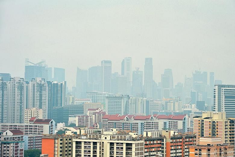 A haze-filled view from a vantage point in Toa Payoh yesterday. The air did not turn unhealthy but the familiar acrid smell and foggy skies were back.