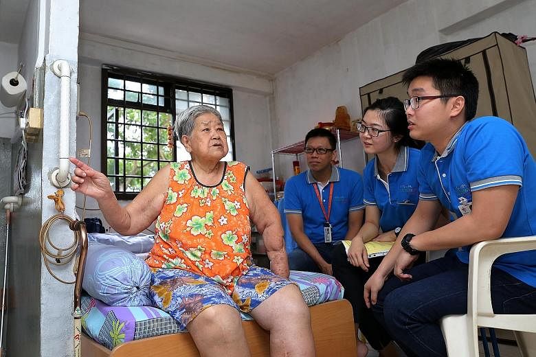 Specialists in training Daniel Hap (right) and Nicole Chen (second from right), together with Prof Nicholas Chew, chat with Madam Ong Kwee Lan, 78, to learn about her daily routine.