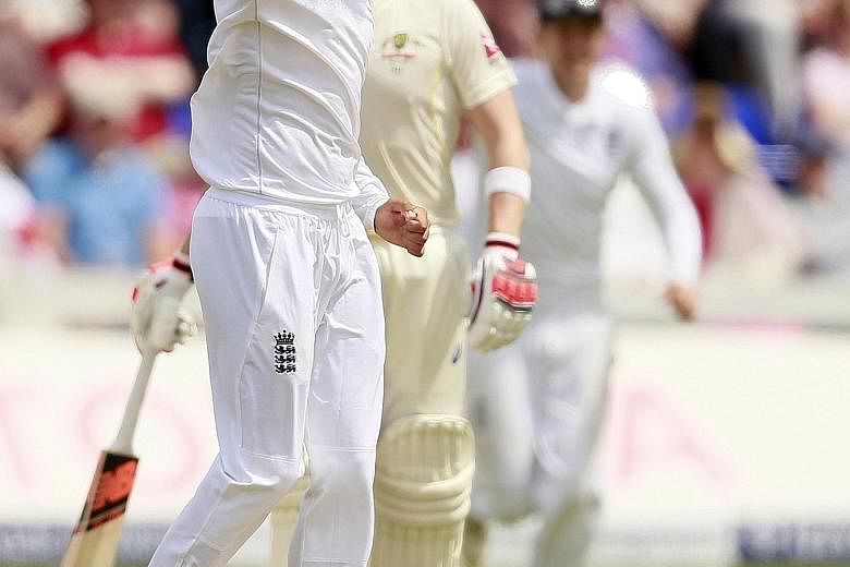 England's Moeen Ali celebrates after taking the wicket of Australia's David Warner.