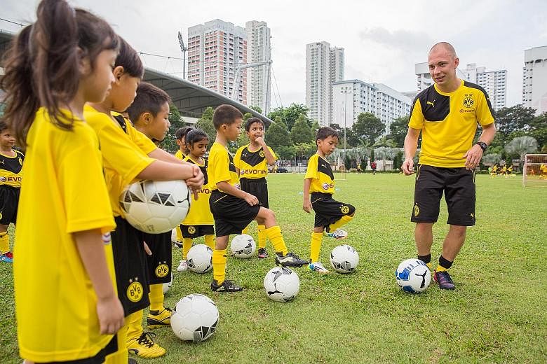 Some 60 children aged five to 12 took part in an hour-long football clinic organised by German Bundesliga club Borussia Dortmund's youth-team coaches yesterday morning. The event, held at the People's Association headquarters, was organised by chemic