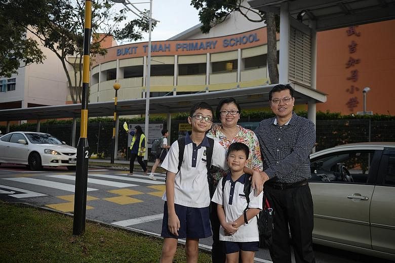 Madam Chua Huay Wen, 39, her husband Kenneth Seah, 43, and their children Jonathan (left), 11, and Matthew, eight, outside Bukit Timah Primary School, which sits among private estates and "brand-name" schools such as Pei Hwa Presbyterian and Methodis