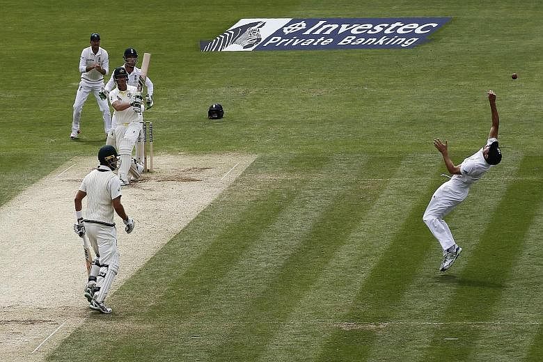 England captain Alastair Cook (right) makes a stunning catch to take the wicket of Australia's Brad Haddin during the fourth day of the opening Ashes cricket Test. The hosts' emphatic 169-run win laid bare the problems with the visitors' batting and 