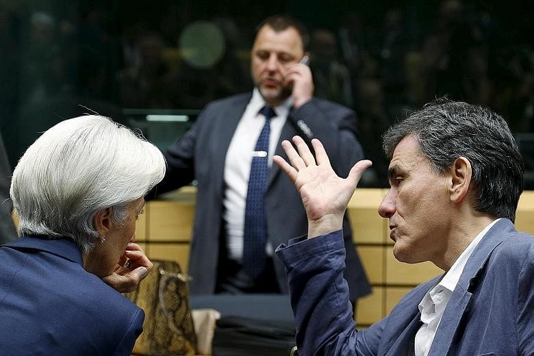 Ms Christine Lagarde, chief of the International Monetary Fund, a creditor, and Greek Finance Minister Euclid Tsakalotos in talks during a meeting of euro zone finance ministers in Brussels yesterday.