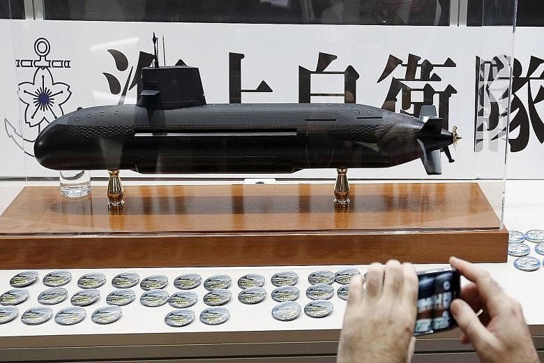 A visitor taking a photograph of a Soryu submarine model at an exhibition in Yokohama in May. Organisers said it was the first military industry trade show in Japan, and the first anywhere to feature Japanese manufacturers.
