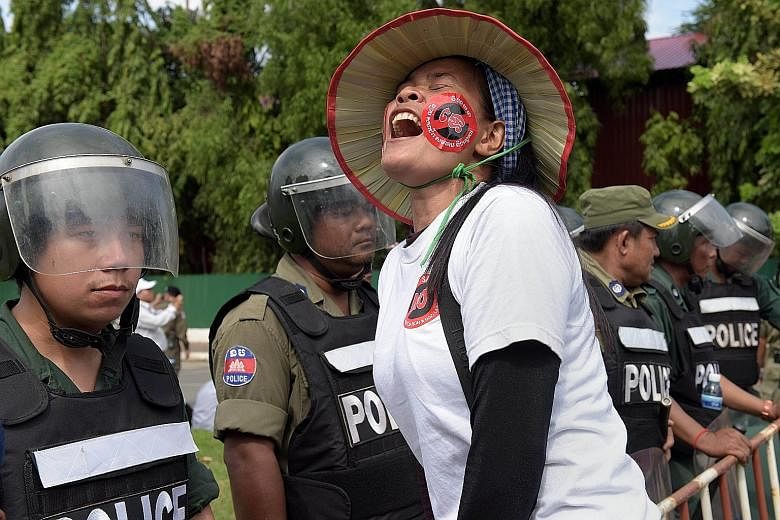 A Cambodian protester shouting slogans in front of a police line near the National Assembly in Phnom Penh on Monday. More than 700 people protested outside the National Assembly as members of the ruling party passed the law.
