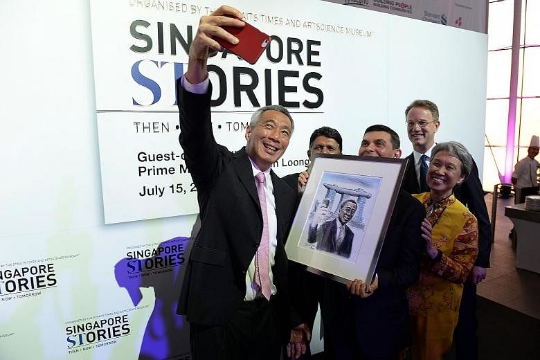 PM Lee taking a wefie with (from left) SPH English, Malay, Tamil Media Group editor-in-chief Patrick Daniel, ST editor Warren Fernandez, Marina Bay Sands chief George Tanasijevich and Mr Lee's wife Ho Ching. A drawing of Mr Lee taking a selfie agains