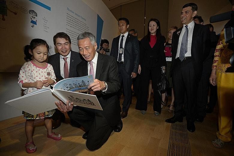 PM Lee taking a wefie with (from left) SPH English, Malay, Tamil Media Group editor-in-chief Patrick Daniel, ST editor Warren Fernandez, Marina Bay Sands chief George Tanasijevich and Mr Lee's wife Ho Ching. A drawing of Mr Lee taking a selfie agains