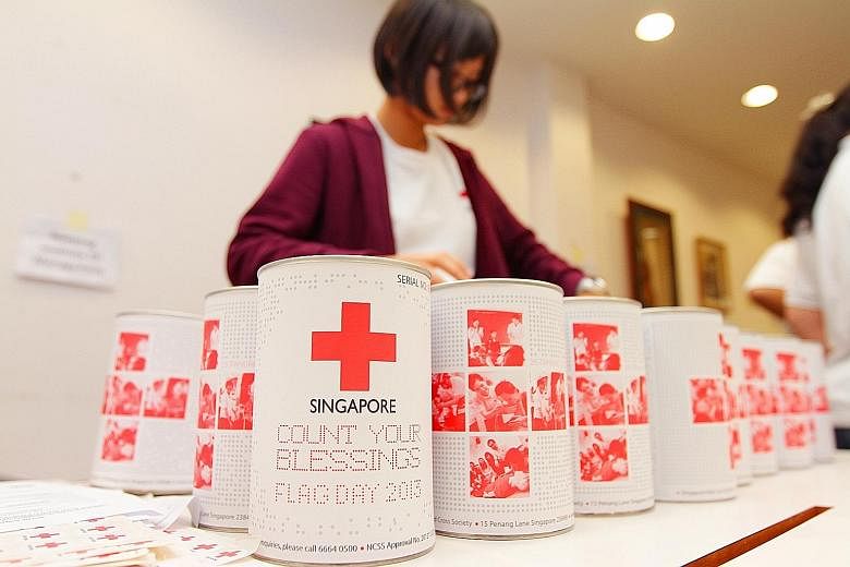 A Singapore Red Cross volunteer organising the donation tins to be used on its Flag Day. Tax-deductible donations to charity hit $1.1 billion last year - a more than 12 per cent increase from the year before, and the highest in at least 16 years.