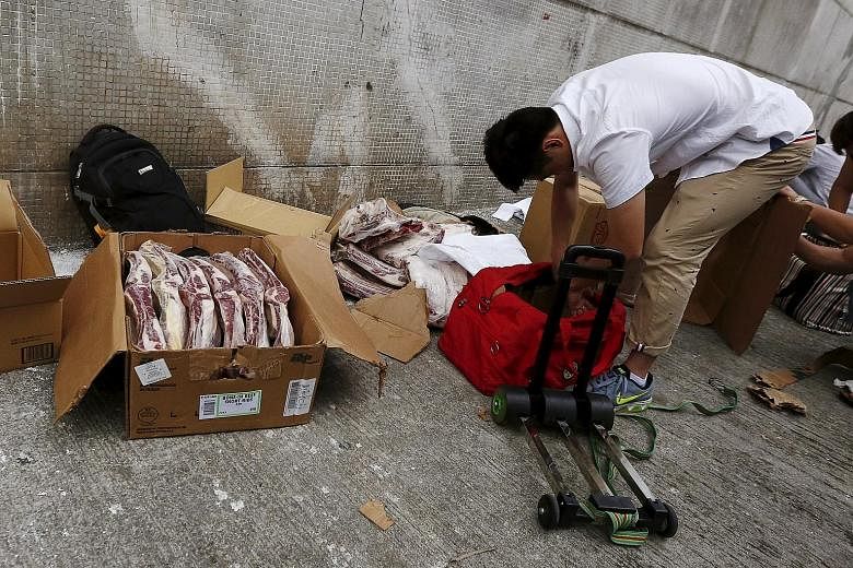 Boxes of frozen beef ribs from the US being unpacked on a side street in a Hong Kong industrial area on Monday, before they are hand-carried and smuggled into mainland China.