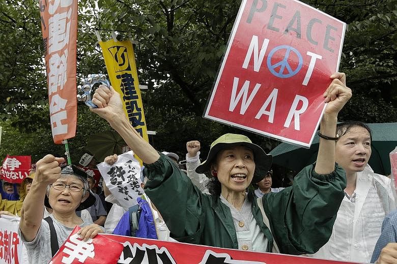Japan's Premier Shinzo Abe wants to put in place a security framework that will allow the Self Defence Force (above) to take part in military operations with the US and other countries. But huge rallies have been held against the "war Bills", such as