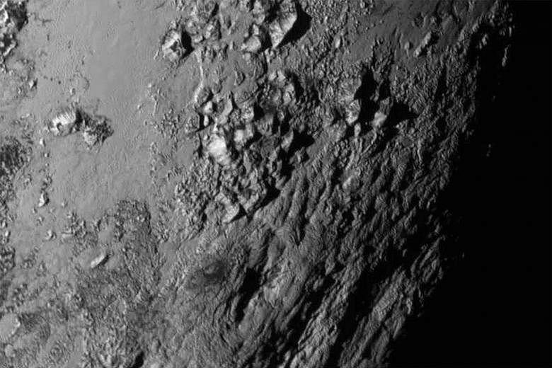 A handout from Nasa (far left) shows Pluto and its largest moon Charon in false colour image. Charon is shown to have canyons and cliffs. A close-up image (left) from Nasa of a region near Pluto's equator reveals a giant surprise: a range of youthful