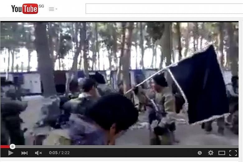 A screenshot from the video clip showing Indonesian-speaking men in military fatigues and armed with rifles preparing for a field assignment. The clip is the latest to show the existence of the Malay archipelago unit for ISIS.