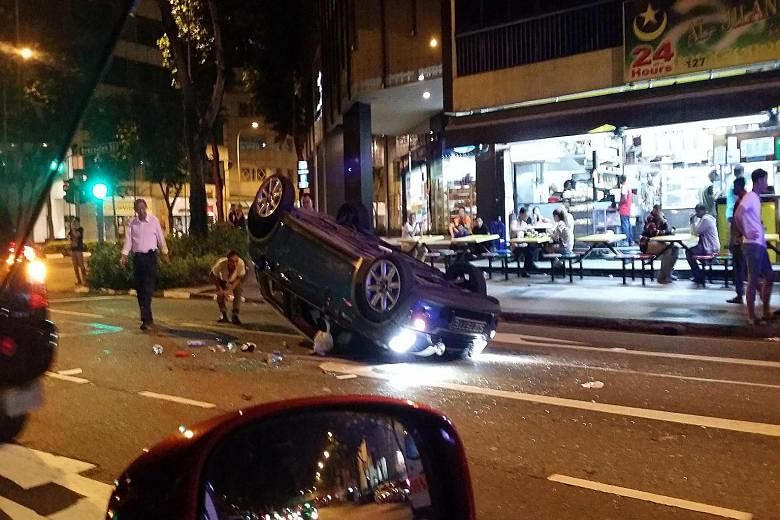 The Mini Cooper ended upside down after crashing into a parked car. The Mini's female driver was taken conscious to hospital along with the driver of the parked Toyota Vios. A passer-by is also believed to have been hurt.