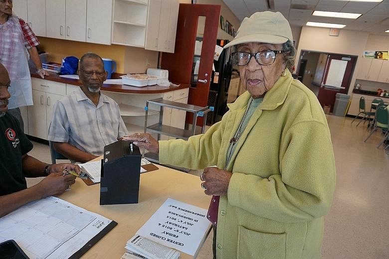 Ms Corrine Whoie, 93, dropping US$1 in the donation box, to cover her meal at the Hattie Holmes Senior Wellness Centre in Washington, DC. Its lunch programme aims to provide seniors with nutritious food five days a week.