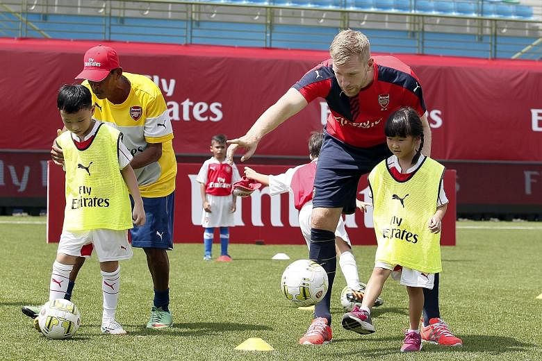 The Straits Times gave 40 out of 65 children between the ages of six and 12 a chance to play with Arsenal stars, including Per Mertesacker (above) and Mesut Oezil, at the Emirates Football Clinic. Faith Lim, seven, was one of the lucky ones. She said
