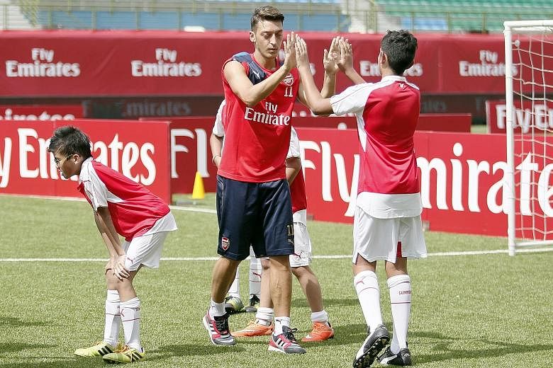 Mesut Oezil at an Emirates clinic yesterday. He and manager Arsene Wenger dismissed the notion that he is unhappy at Arsenal.