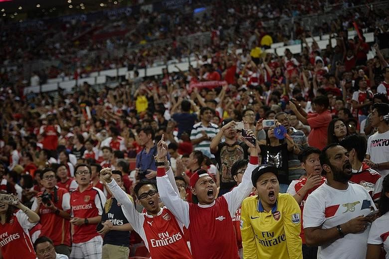Fans at the National Stadium watching last night's match between Arsenal and Everton. A record 52,107-strong crowd watched the Gunners beat Everton 3-1 to win the Barclays Asia Trophy.