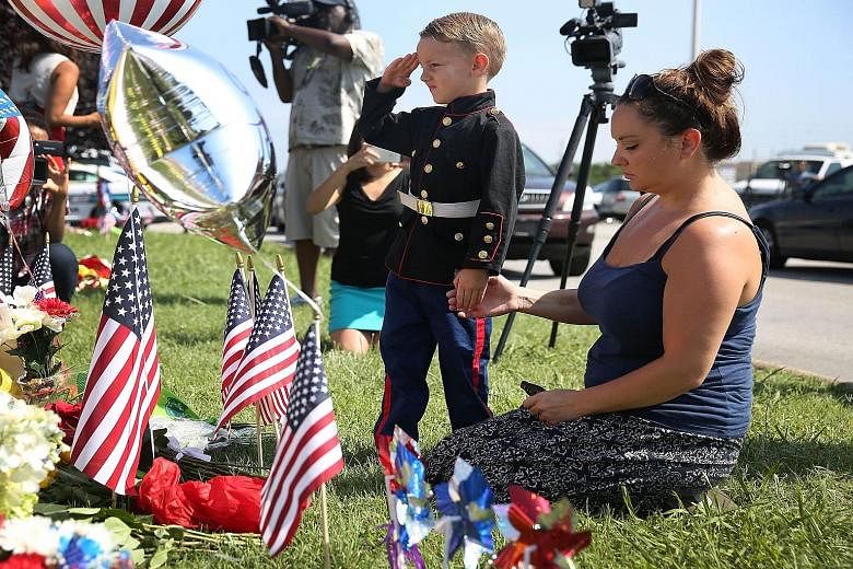 Blake Miller and his mother Ashley paying their respects to those killed while visiting a memorial in front of the Armed Forces Career Centre/National Guard Recruiting Office, which was one of the sites where the shootings took place.