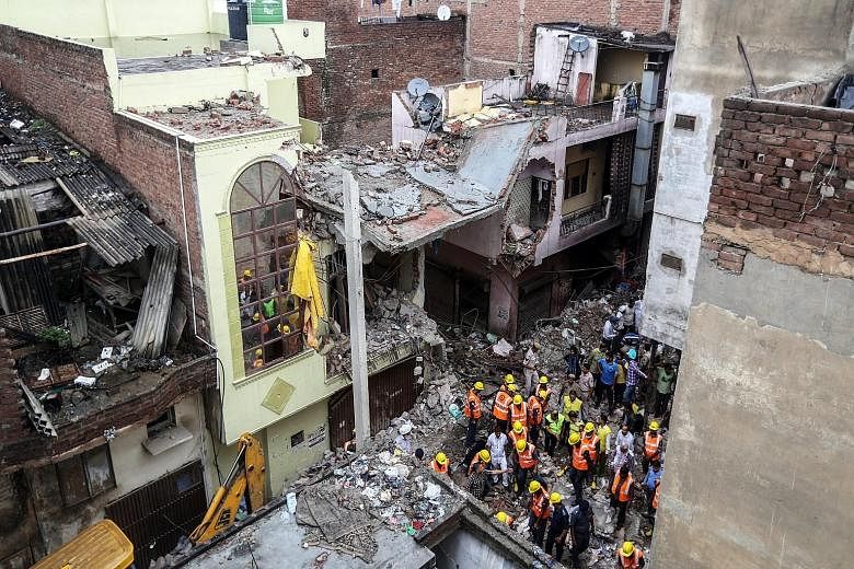 Rescue workers sifting debris at what used to be a four-storey building in the Vishnu Garden neighbourhood in western Delhi yesterday. The accident is the latest in a long line of deadly building collapses in India, some of which pointed to shoddy co