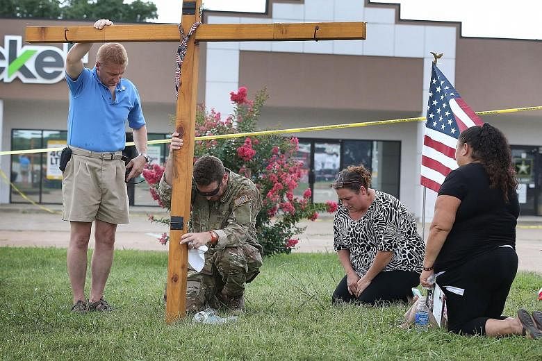 (Right) Mourners at a memorial set up in front of the joint military recruiting office in Chattanooga, Tennessee. A gunman had opened fire on the office on Thursday before driving to an operational support centre, where he killed four US Marines and 