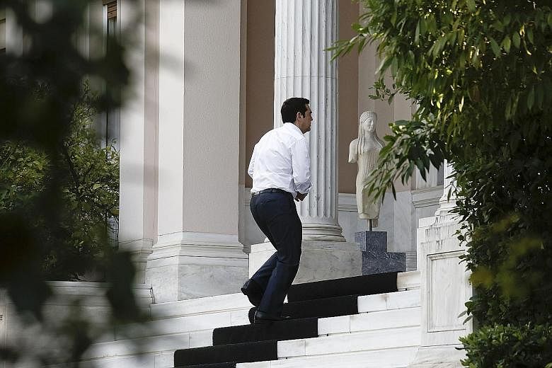Mr Alexis Tsipras arriving at Maximos Mansion, the official seat of the Prime Minister in Athens, last Wednesday, before 229 Greek lawmakers voted in favour of measures demanded by Greece's creditors as a condition for further aid, with 64 voting aga