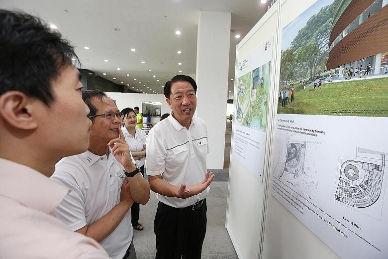 Deputy Prime Minister and MP for Pasir Ris-Punggol GRC Teo Chee Hean (right) looking at the new hawker centre's layout and artist's impressions during the ground-breaking ceremony yesterday.
