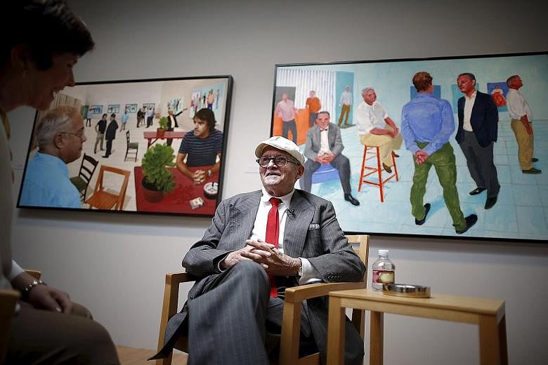 Artist David Hockney in front of his artwork The Red Table (far left) and The Group V (left).