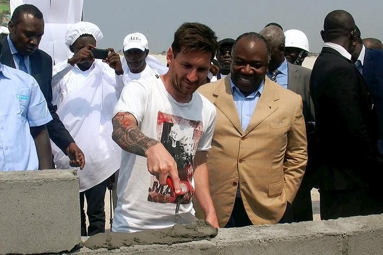 Lionel Messi, accompanied by Gabon President Ali Bongo Ondimba, laying the first stone at a future African Cup of Nations venue in Port-Gentil on Saturday. He is not in the United States for Barcelona's pre-season tour, having been given an extended 