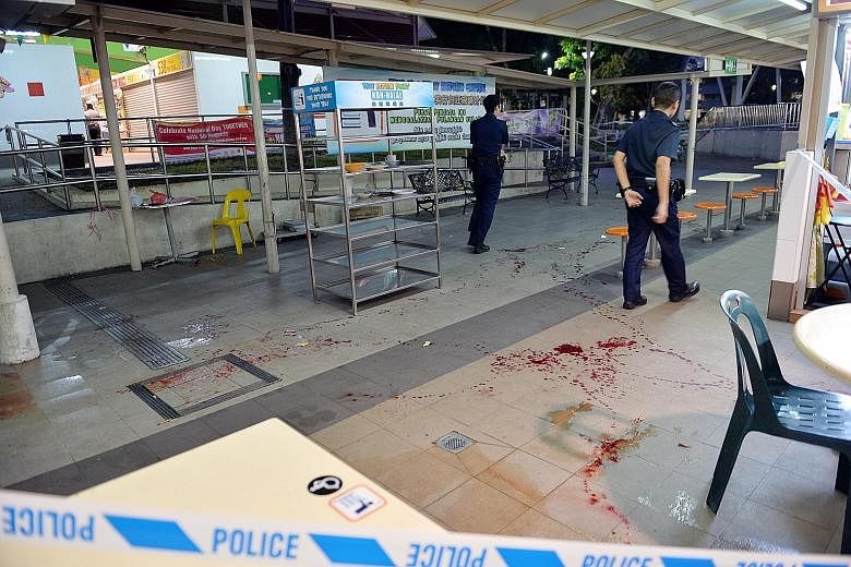 Police at the Bedok North hawker centre yesterday, where a young man ended up after being chased by his attacker. The victim has since been hospitalised.