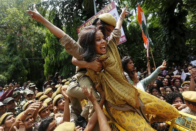 A policewoman trying to stop a member of the All India Mahila Congress from crossing a barricade during a protest against Indian Prime Minister Narendra Modi in New Delhi yesterday. Mr Modi's government aims to push through reforms to revive the econ