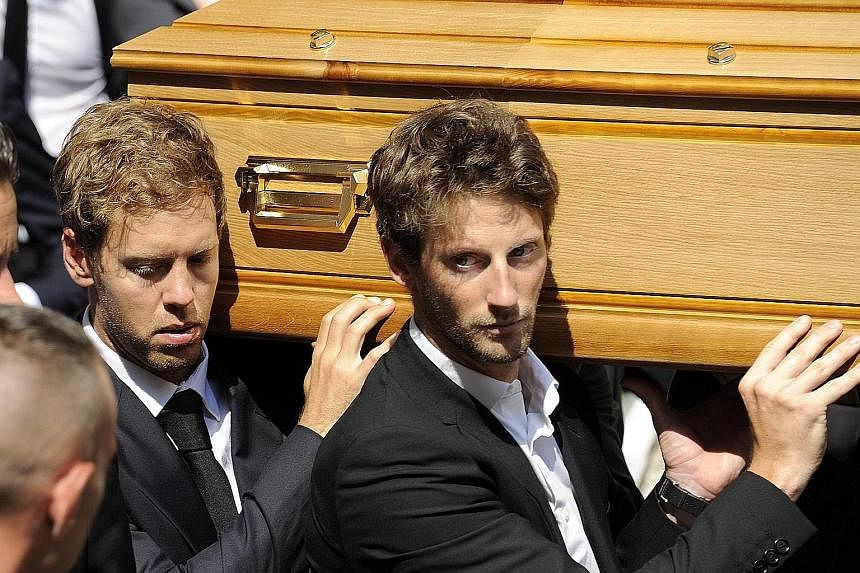 Formula One drivers Sebastian Vettel (left) and Romain Grosjean join pallbearers carrying the coffin of Jules Bianchi during his funeral in Nice yesterday.