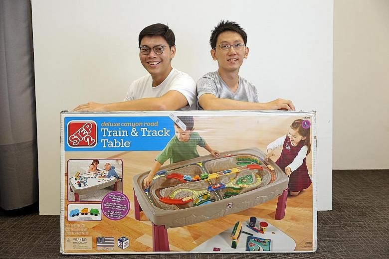 Airfrov founder Cai Li (far left) and Robi with a massive toy train set from the US which was requested by a user of their site - and lugged back to Singapore by another user.