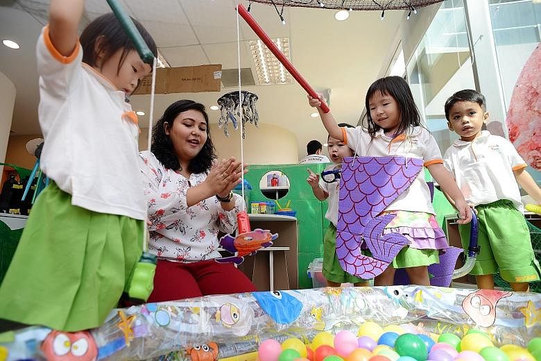 English teacher Qamariza Jamaludin, 31, with some of her charges at the Westgate shopping mall branch of My First Skool, which comes under NTUC First Campus. Under the new curriculum, one teacher is allocated to every two to three children, instead o
