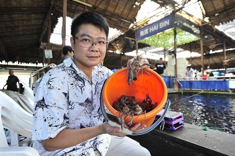 Mr Anthony Lim, with a bucket of river crayfish straight out of the pond.