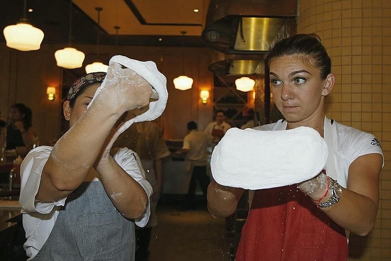 Topping off her talents, Simona Halep learns how to stretch pizza dough at the Shoppes at Marina Bay Sands yesterday.