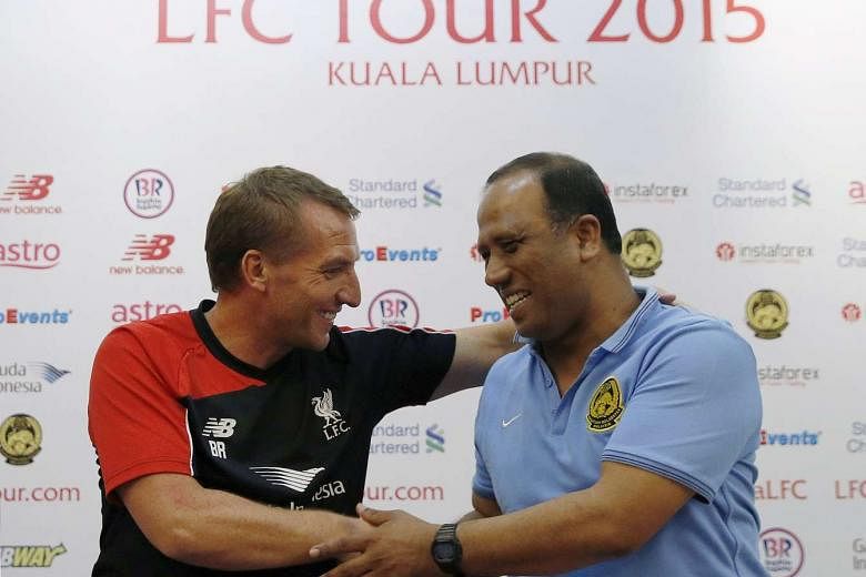 Liverpool manager Brendan Rogers shaking hands with Malaysia XI coach Dollah Saleh (right) at a news conference yesterday, ahead of their friendly match in Kuala Lumpur tomorrow. 